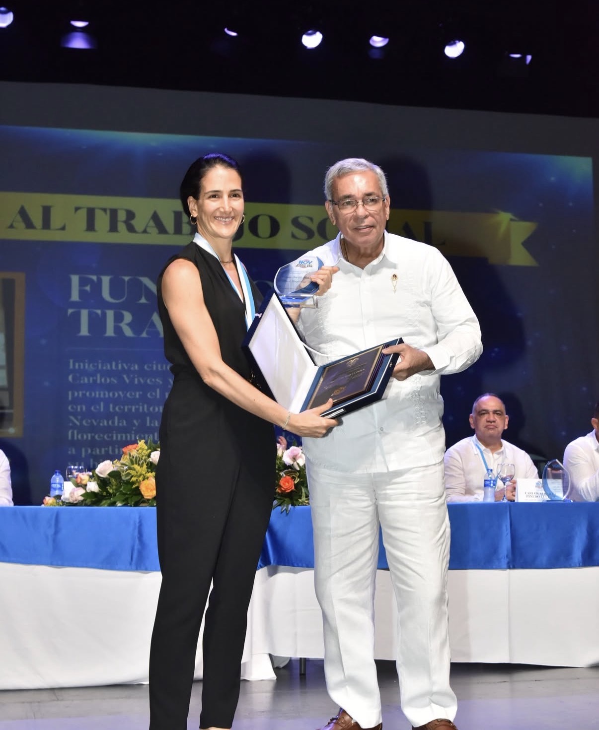 Ulilo Acevedo, Director de Hoy Diario del Magdalena, entregando el reconocimiento de "Trabajo y gestión social" a Isabel Vásquez, Directora Ejecutiva de Tras La Perla, en el Teatro Santa Marta.